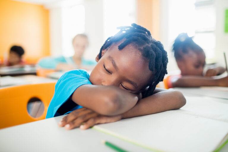 Jeune garçon dormant en classe